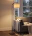 Arc floor lamp glowing warmly beside window on a rainy day