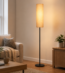 Modern linen floor lamp beside armchair in living room