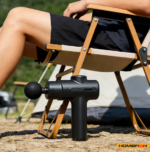 camping-muscle-recovery-uk.jpgPerson using a portable percussion massage gun outdoors while relaxing on a camping chair, demonstrating its compact and travel-friendly design – UK